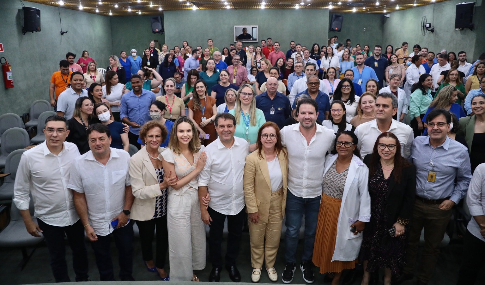 grupo de pessoas posa para a foto no auditório do IJF